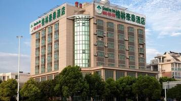 A multi-story hotel with a modern architectural design, featuring a prominent glass facade and a series of balconies.
