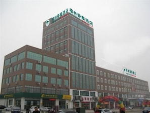A multi-story hotel building with a prominent sign at the top. - GreenTree Inn Wenshang Baoxiang Temple Express Hotel (Jining)