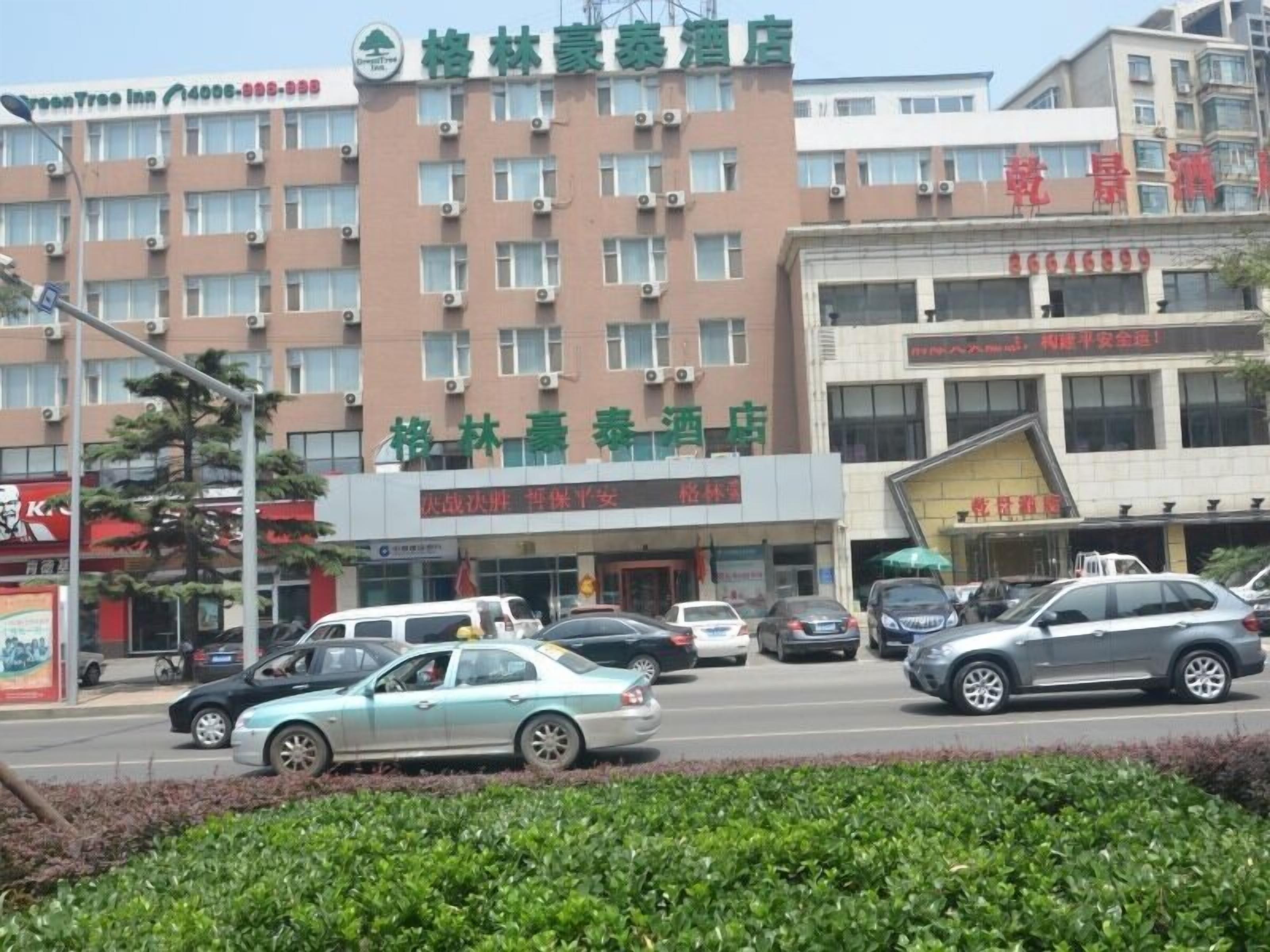 A hotel with multiple floors, air conditioning units, and a signboard with Chinese characters.