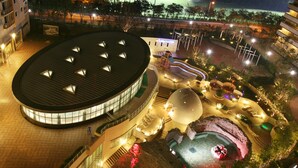 Un hôtel moderne doté d’un bâtiment circulaire, d’une cour intérieure et d’une piscine.