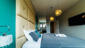 A modern hotel room with a large bed, a bedside table, a mirror, and a TV mounted on the wall. - Oxygen Central Apartments (Warsaw)