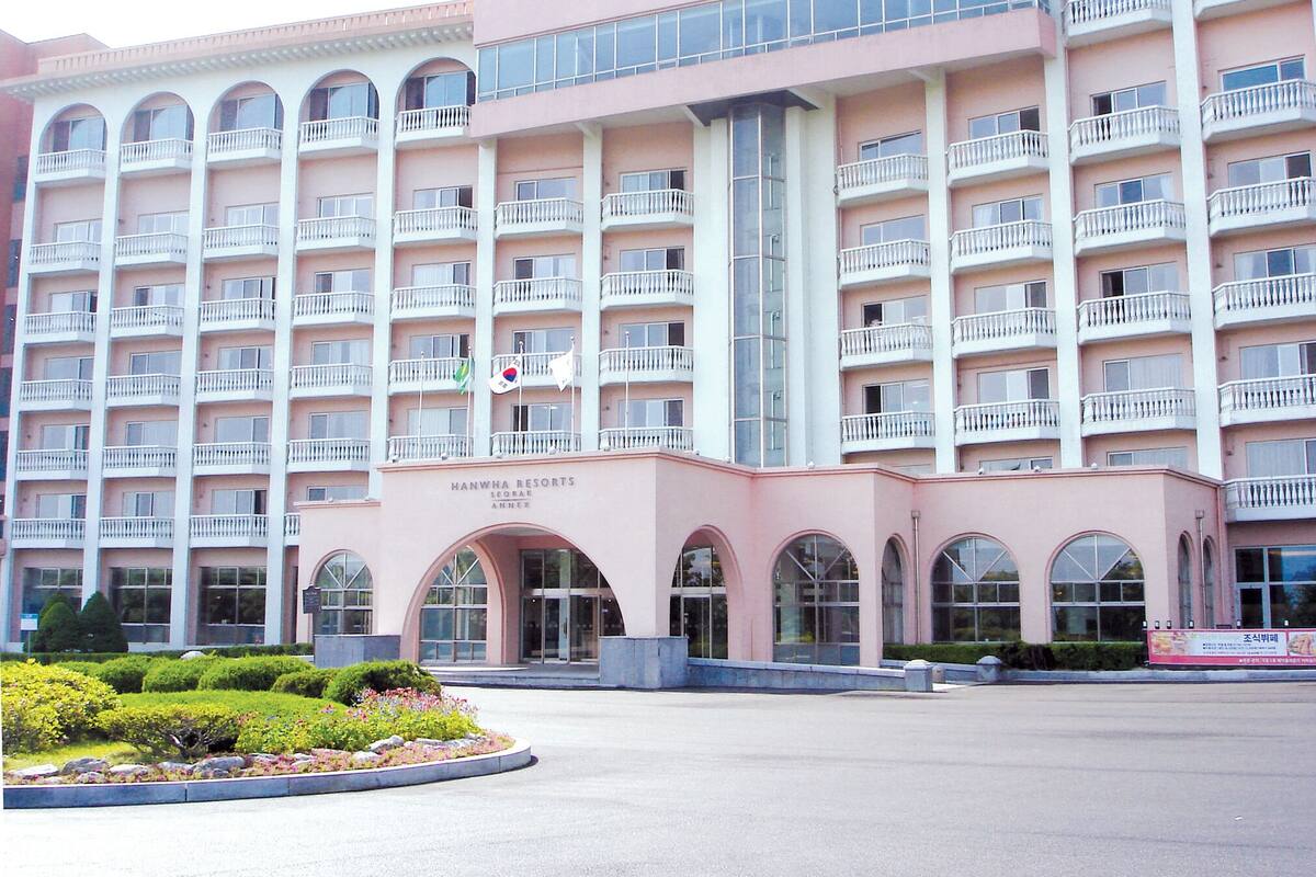 Ein mehrstöckiges Hotel mit Balkonen, einem zentralen Eingang und einem Schild, das angibt, dass es sich um Hanwha Resorts handelt.