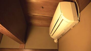 A ceiling with a white air conditioning unit mounted on a wall.