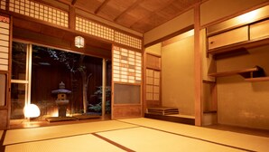 A traditional Japanese room with tatami flooring, sliding doors, and a lantern. - Guesthouse YULULU (Kyoto)