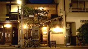 A building with a sign reading "Yoshida Guesthouse" and a bicycle parked outside. - Guesthouse YULULU (Kyoto)