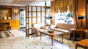 A modern hotel lobby with a sofa set, a coffee table, and a decorative partition. - Alfonso VIII (Soria)