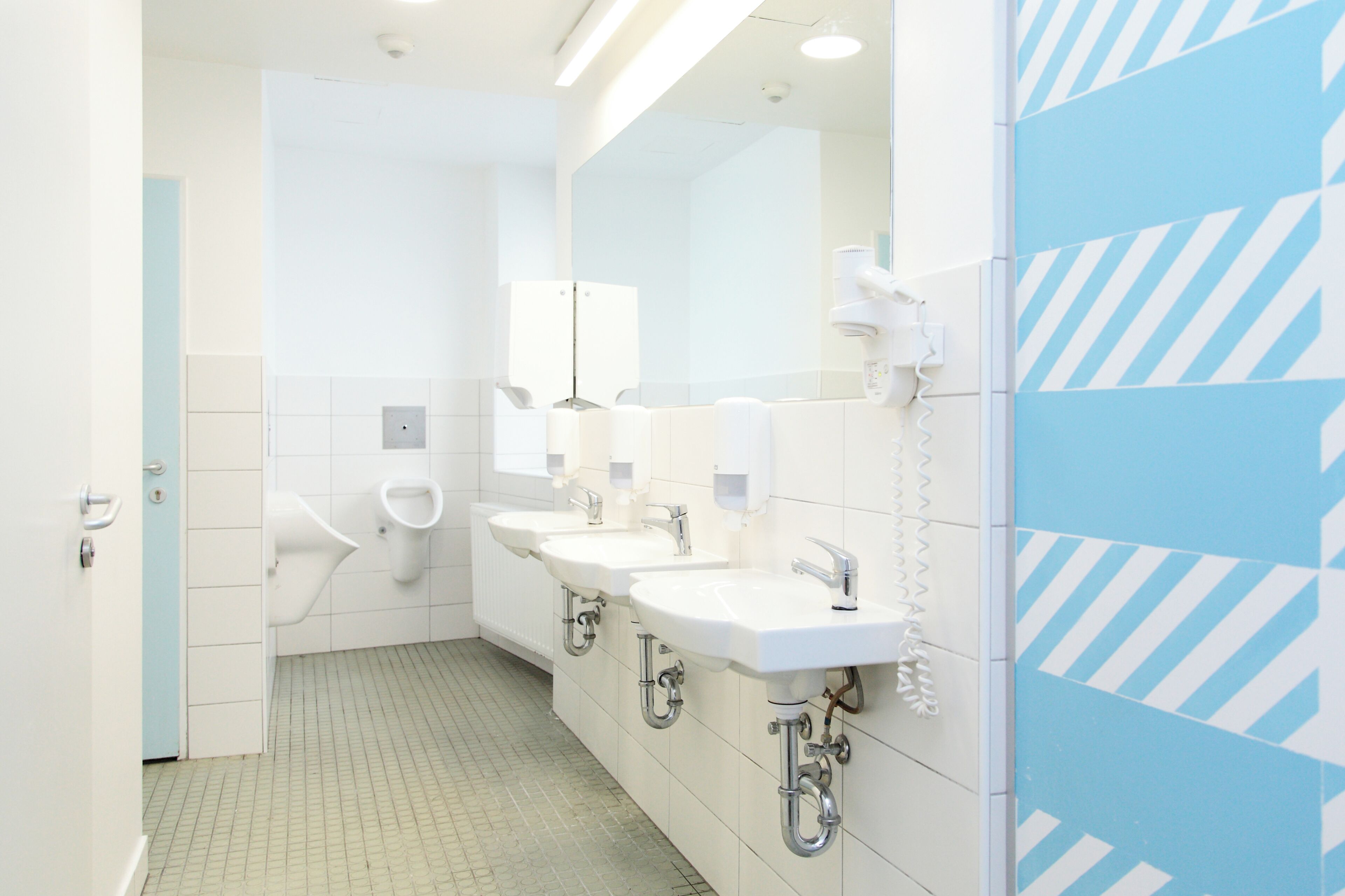 Ein modernes Badezimmer mit zwei Waschbecken, einem Spiegel und einer Toilette.