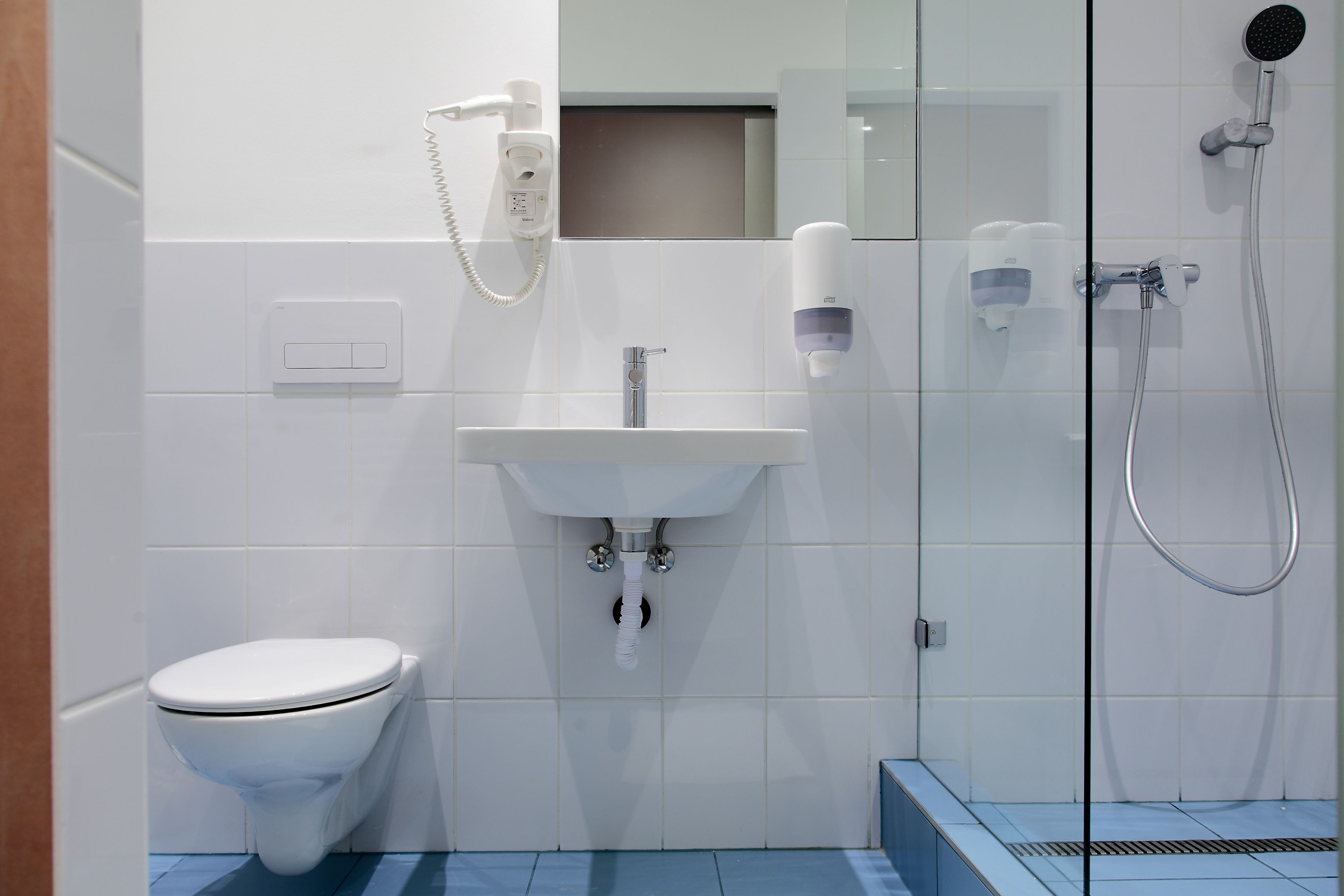 A modern bathroom with a toilet, sink, and shower.