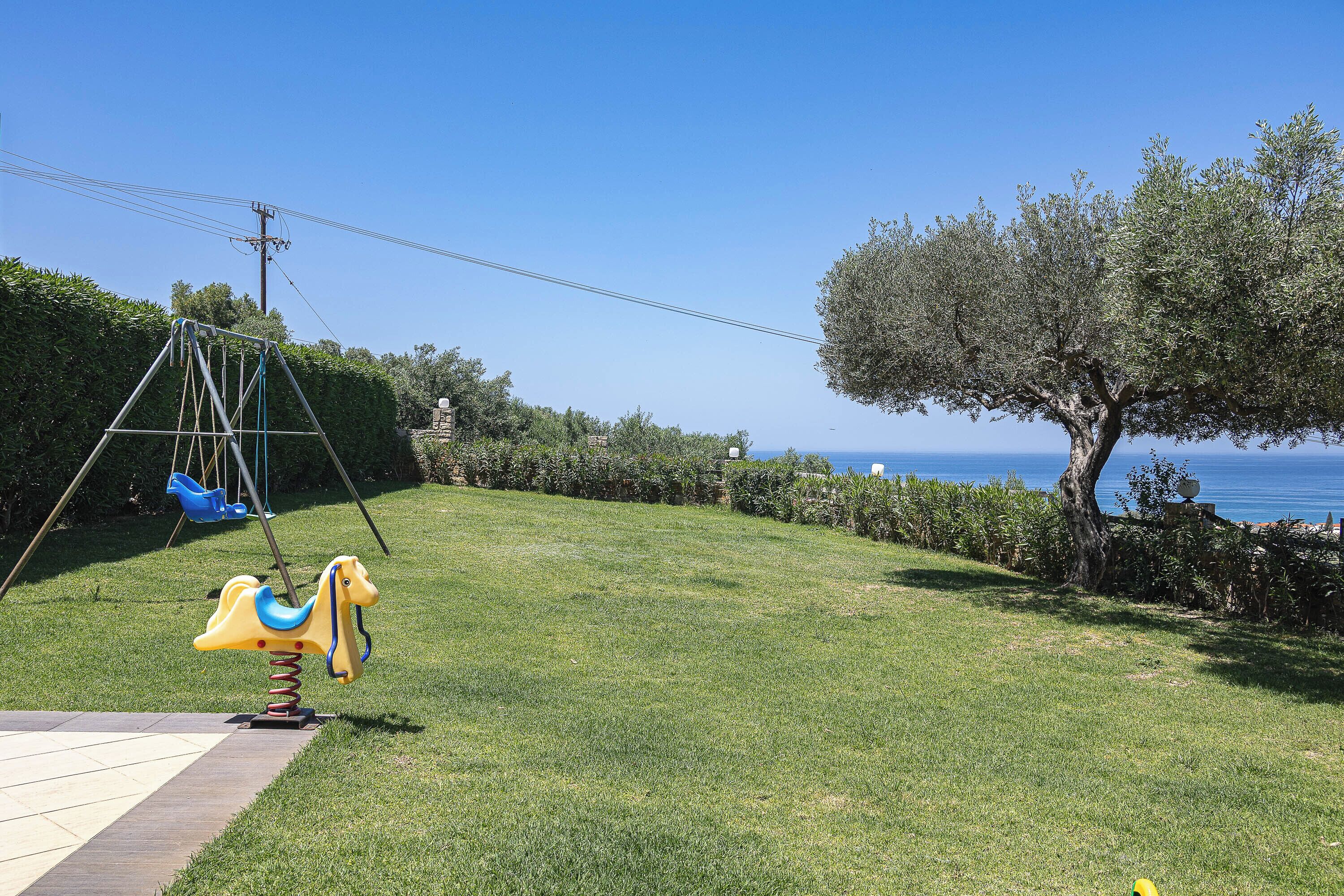 Une zone herbeuse avec une balançoire et un arbre.