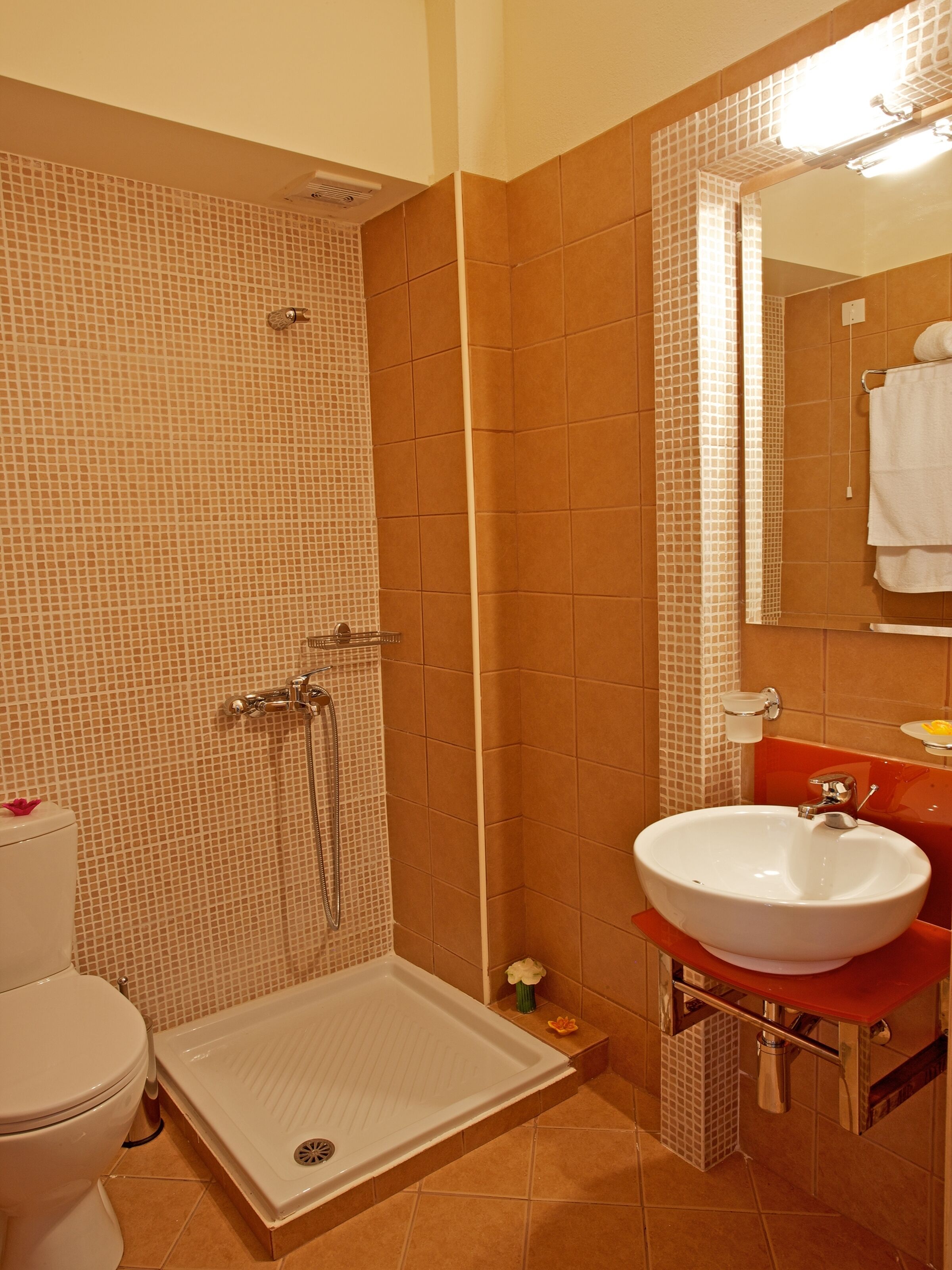 A bathroom with a shower, toilet, and sink.