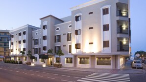 Un hotel de varios pisos con balcones, amplias ventanas y un paso de peatones en la parte delantera.