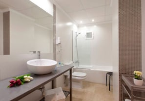 Bathroom features a large round sink, toilet, and shower with glass enclosure.