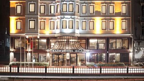 A multi-story hotel with a symmetrical facade, numerous windows, and a central entrance with a canopy.