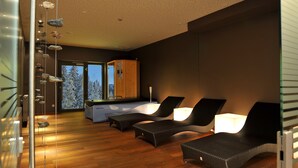 Ein modernes Zimmer mit Holzboden, einer Küchenzeile und zwei Sesseln mit Lampen.