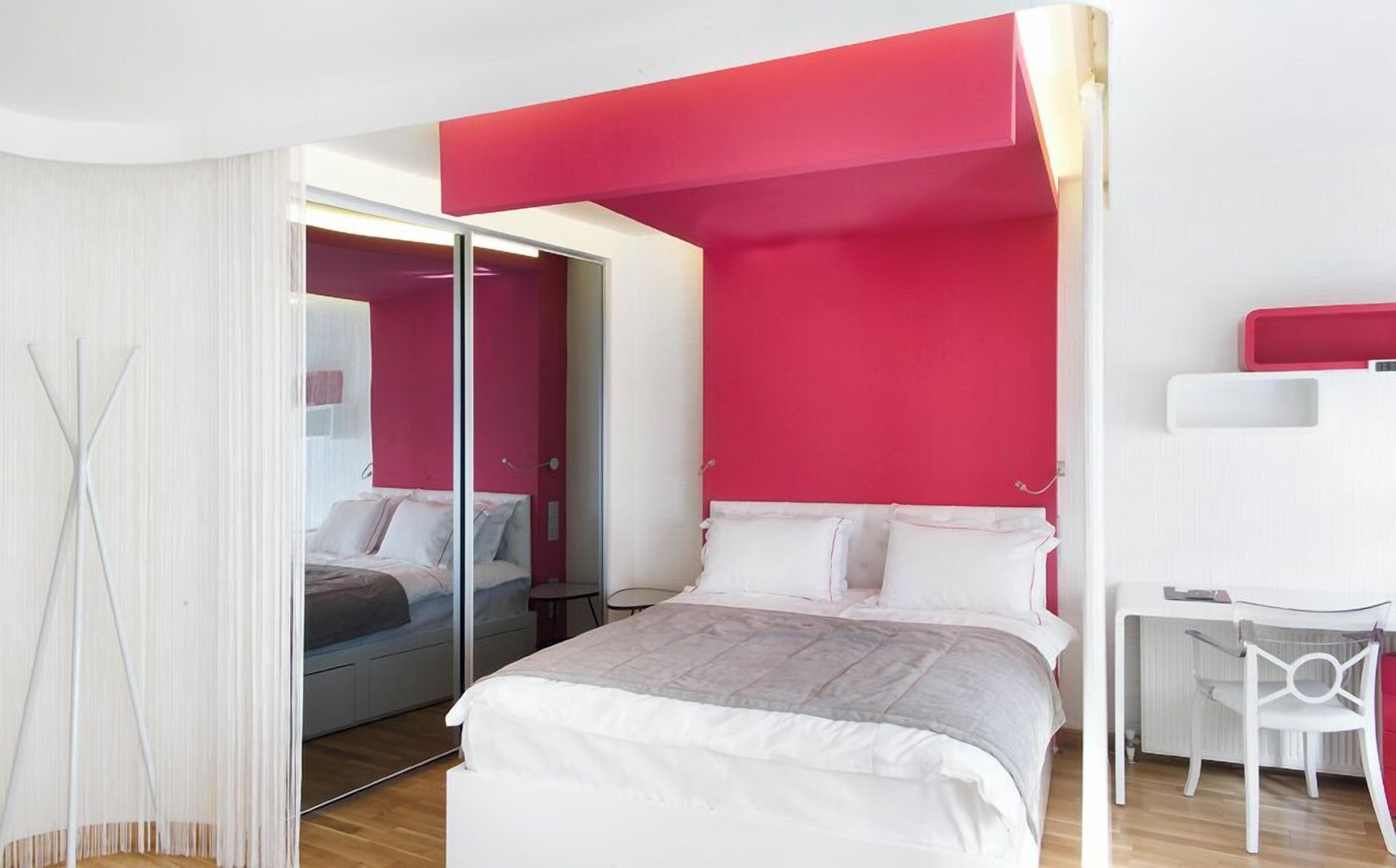 Un dormitorio moderno con una cama, un escritorio y una silla.