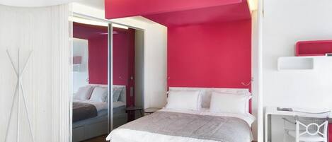 Un dormitorio moderno con una cama, un escritorio y una silla.