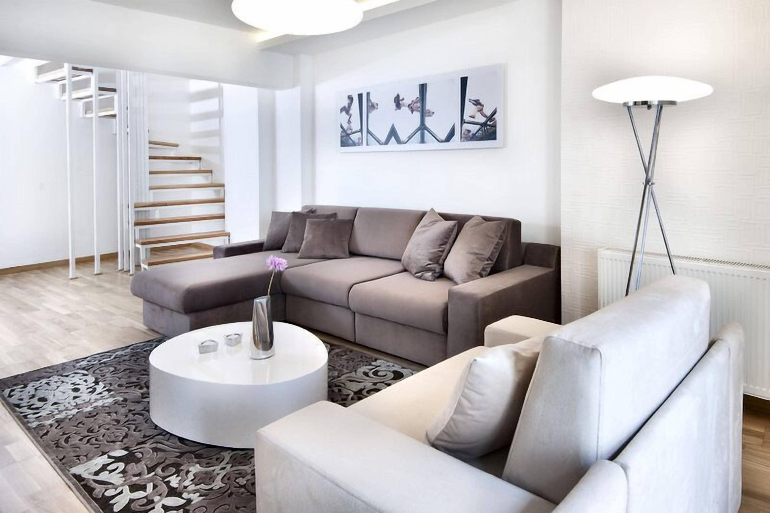 A modern living room with a sofa, a coffee table, and a floor lamp.