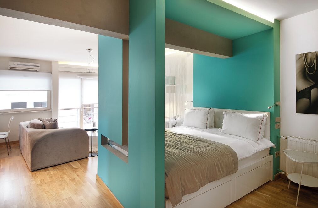 A modern bedroom with a bed, a chair, and a small table.