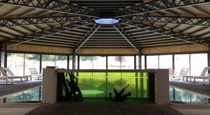 Una piscina techada, sillones reclinables de piscina
