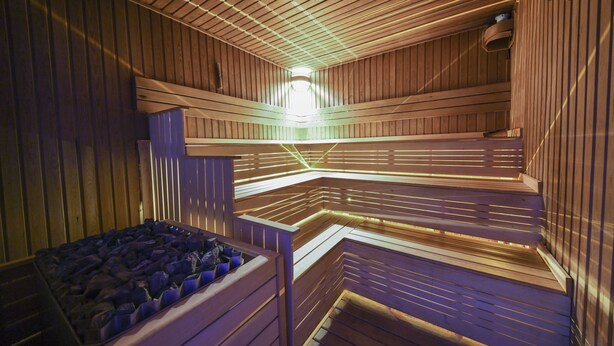 A sauna with wooden benches and a central heating element. - Style Star Hotel Cihangir (Istanbul)