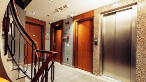 A hotel lobby with a staircase, wooden doors, and an elevator. - Style Star Hotel Cihangir (Istanbul)