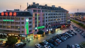 Hotel com vários andares, estacionamento e vista para a rua.