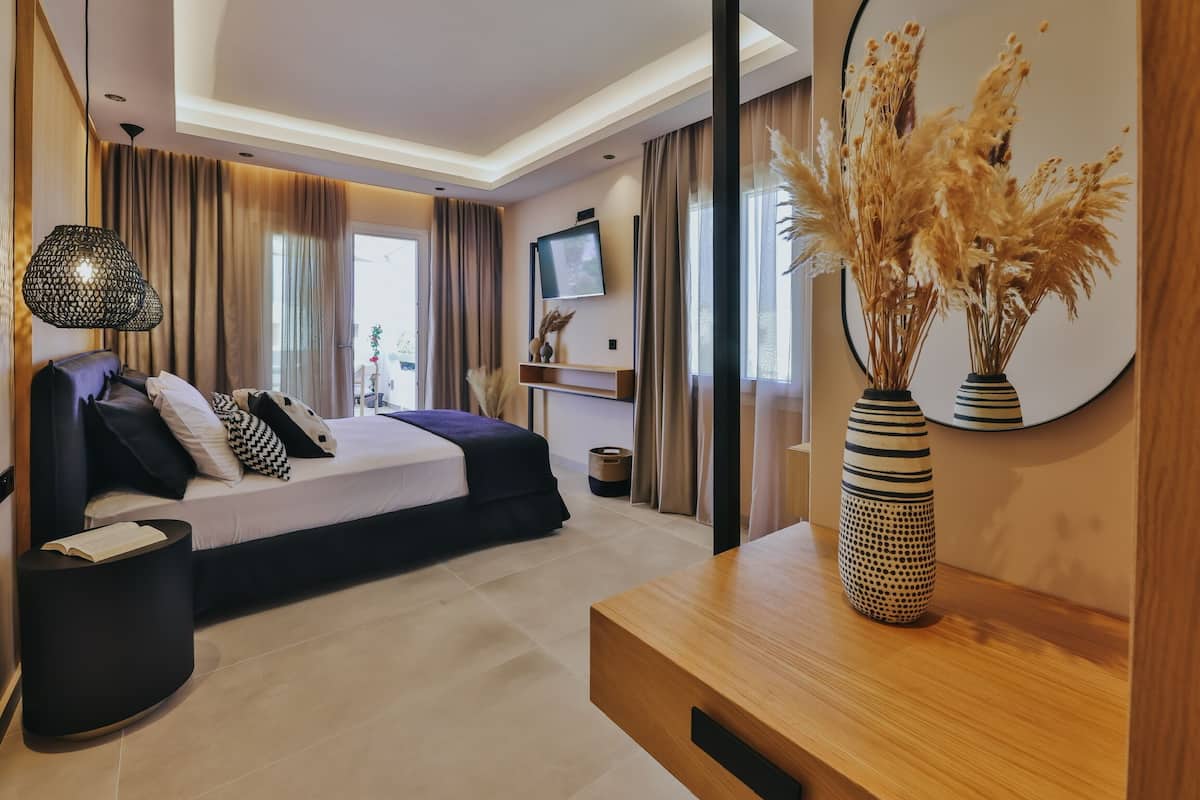 Quarto moderno com cama, mesas de cabeceira, televisão e plantas decorativas.
