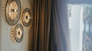 Un salon moderne avec un canapé vert foncé, des coussins à motifs et une plante en pot.