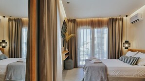 Une chambre d’hôtel avec deux lits, un grand miroir et une vue sur l’extérieur.