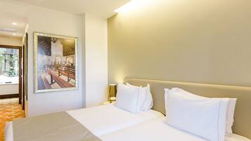 A hotel room with a large bed, a nightstand, a lamp, and a framed picture on the wall.