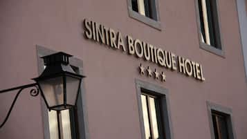 The exterior of Sintra Boutique Hotel with a clear sign, windows, and a street lamp.