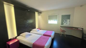 Una habitación de hotel moderna con dos camas, un escritorio y una silla.