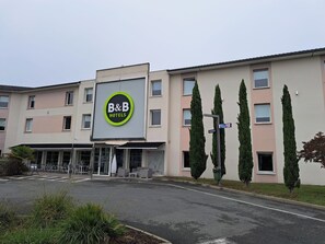 A B&B hotel with a large sign, a parking lot, and a street sign for Canal St. - B&B HOTEL Bordeaux Yvrac (Yvrac)