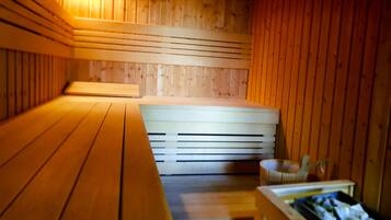 Eine Sauna mit Holzbänken und einer Bank mit Handtüchern.