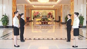 A hotel lobby with a reception desk, potted plants, and a decorative floral arrangement. - GreenTree Huainan Tianjiaan Square Guangchang road Hotel (Huainan)