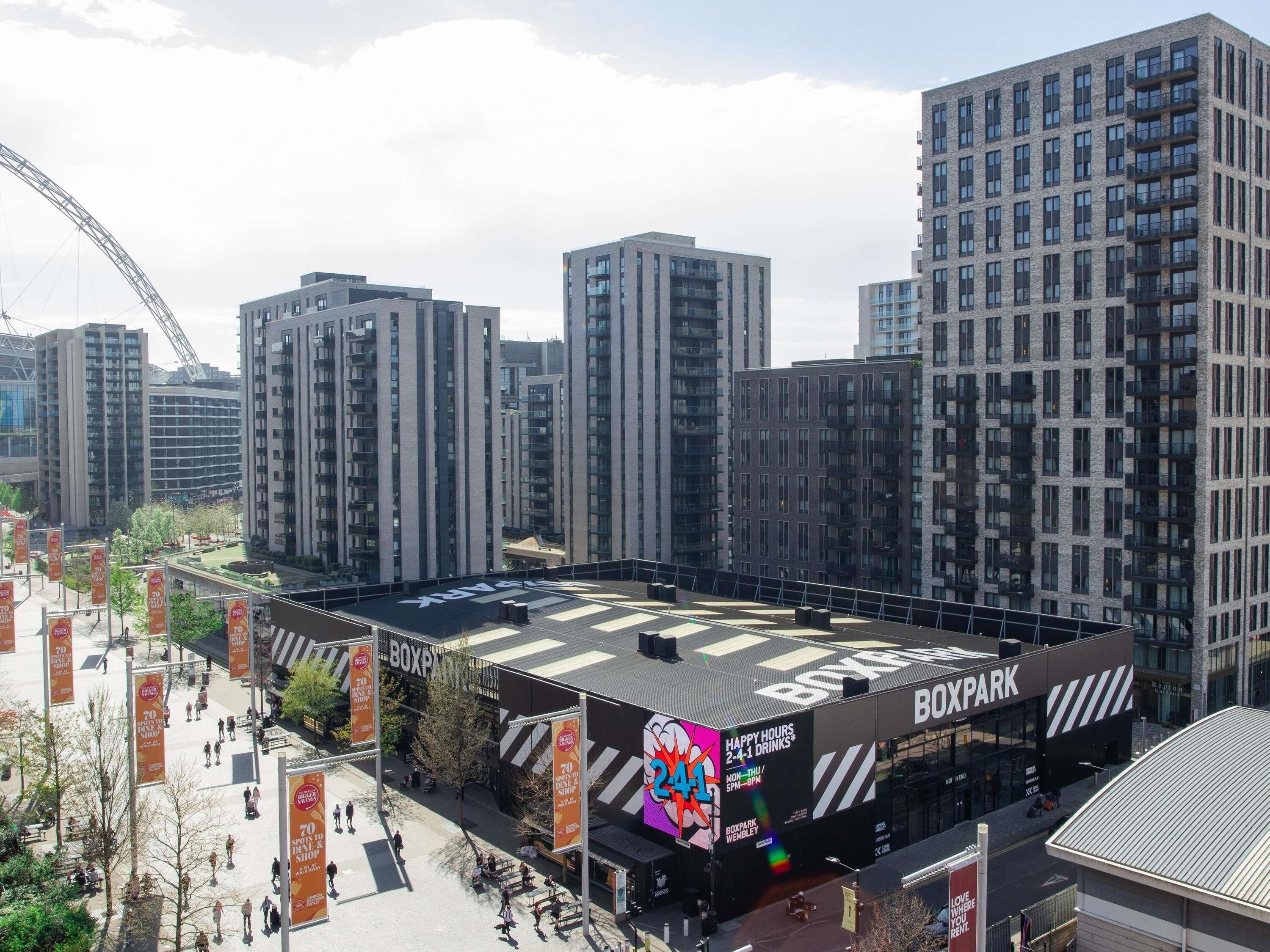 A multi-story building with a flat roof and a large billboard advertising a shop.