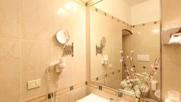A bathroom with a sink, mirror, and a telephone.