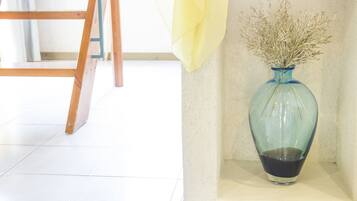 A blue vase with dried plants on a shelf.