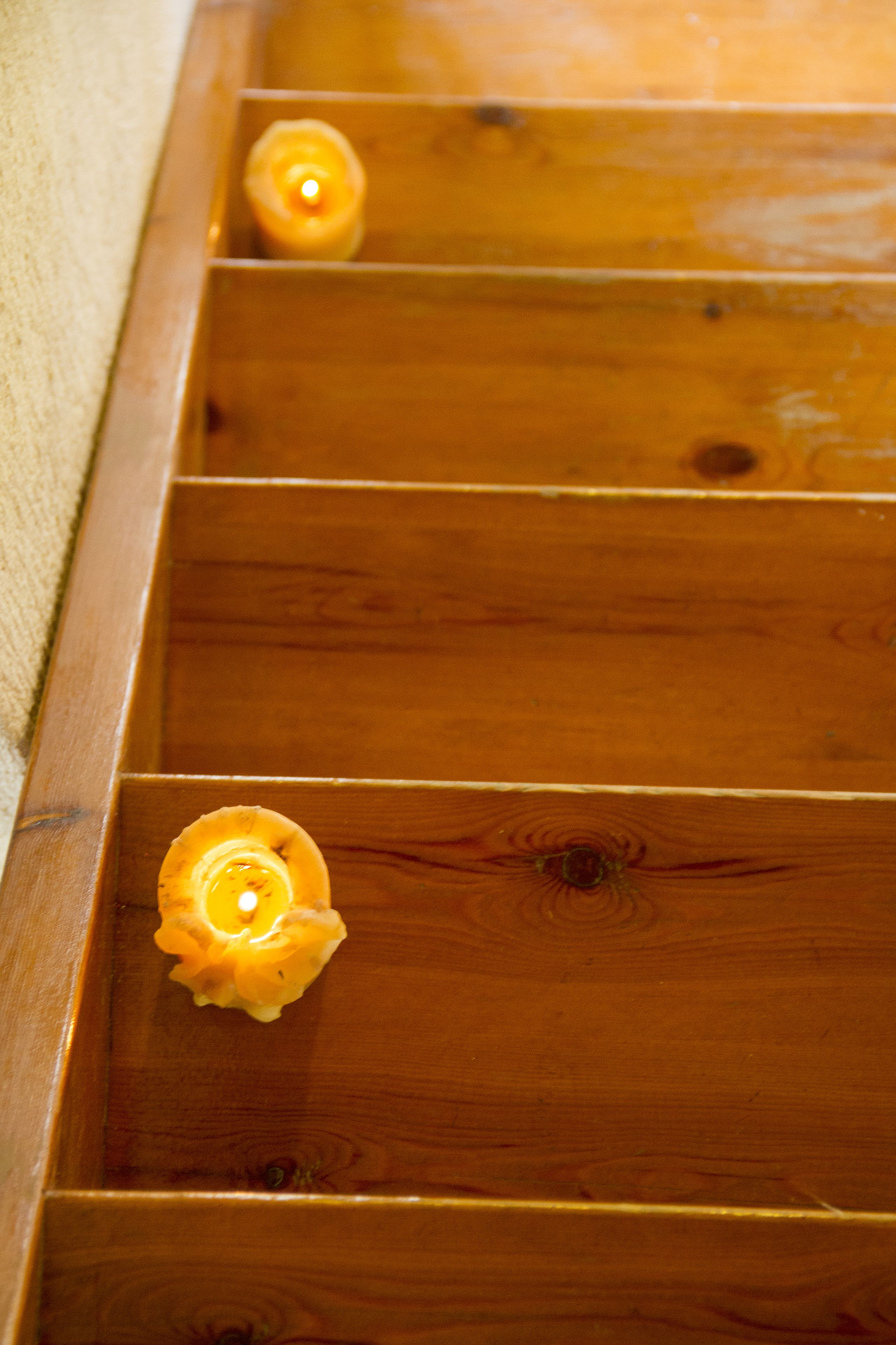 A wooden bench with candles in each compartment.