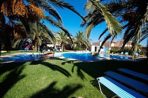 Una piscina al aire libre de temporada, tumbonas