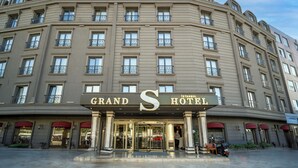 Un hotel grande, su più piani, con un cartello ben visibile che riporta 'Grand S Hotel'.