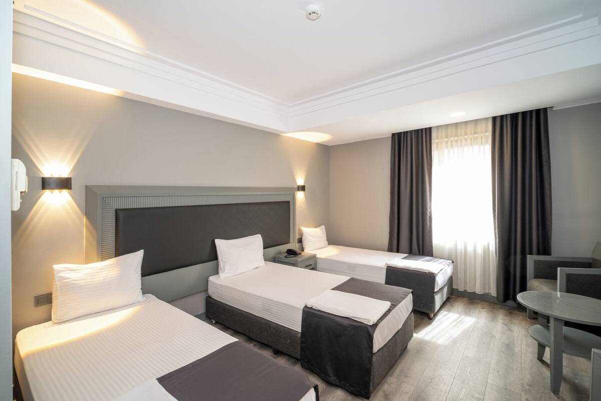 Ein Hotelzimmer mit zwei Betten, einem Schreibtisch und einem Stuhl.