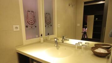 Un baño con un espejo grande, un lavabo y un mueble de tocador con estantes.