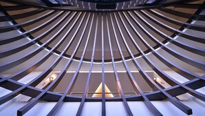 Een modern interieur met een radiaal ontwerp, met een centraal lichtarmatuur en meerdere toegangen.
