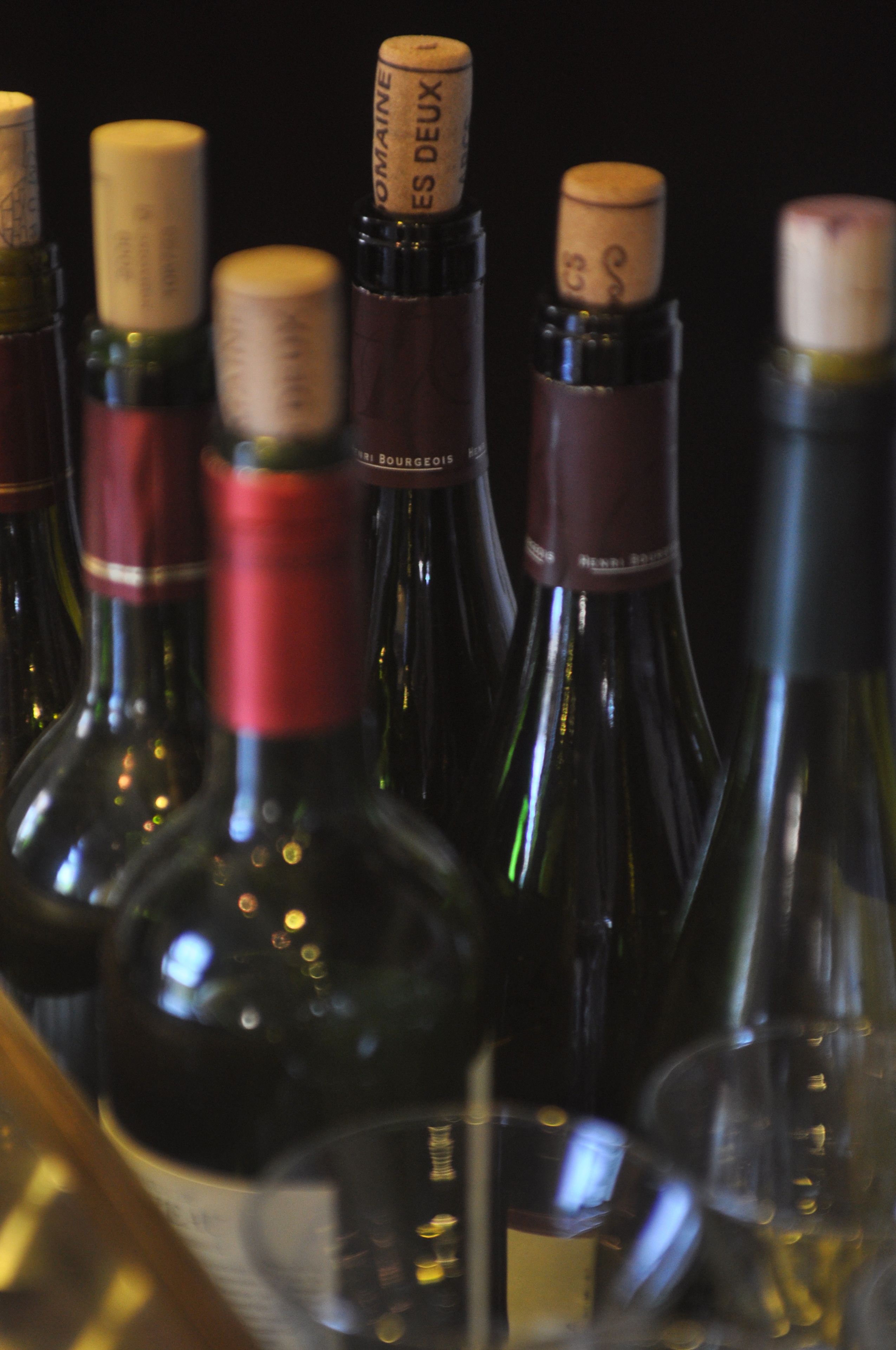 Une collection de bouteilles de vin, fermées par des bouchons, dont certaines portent des étiquettes visibles.