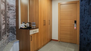 Una habitación con armarios de madera, una encimera con utensilios de cocina y una puerta con cerradura de seguridad.