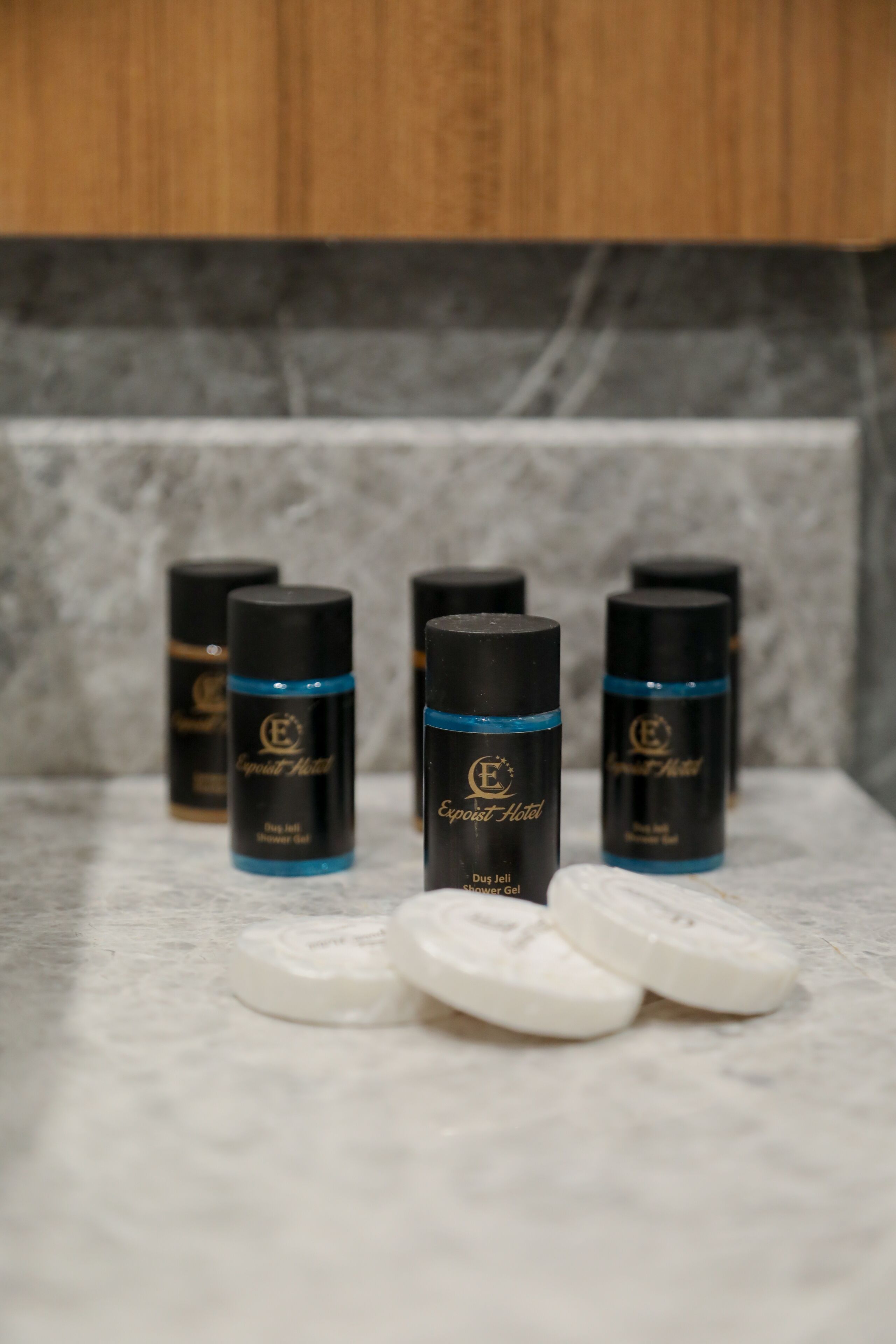 Several black bottles with blue bands and white tablets on a marble surface.
