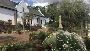 Un edificio blanco con un muro de piedra y una valla de madera.