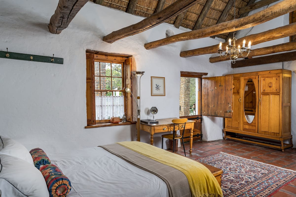Una habitación tradicional con cama, escritorio y armario de madera.