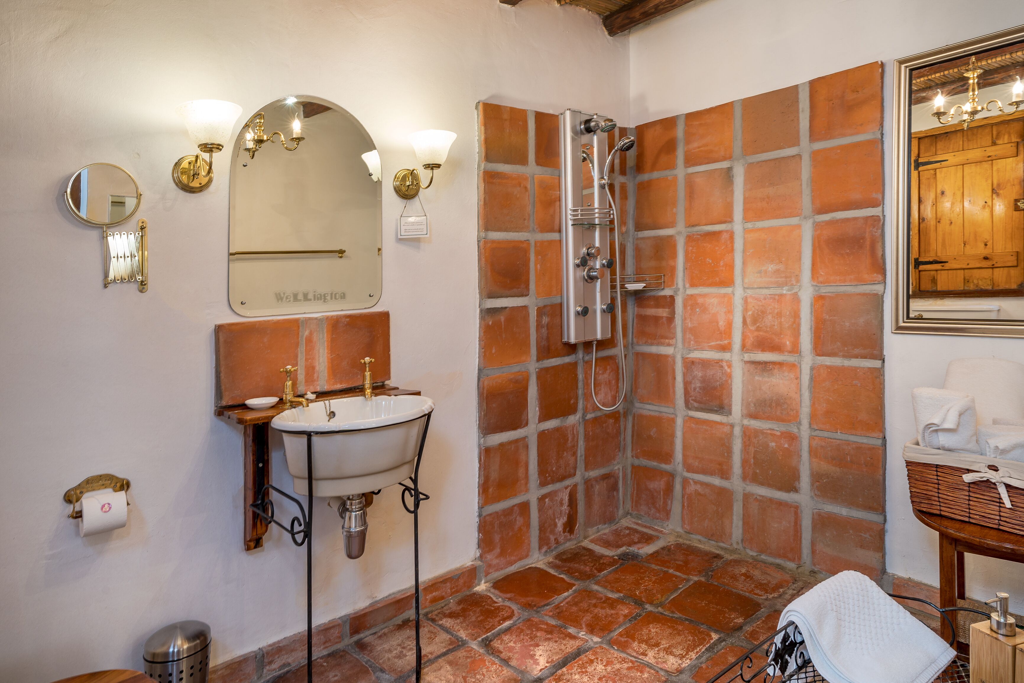 A bathroom with a sink, mirror, and shower.